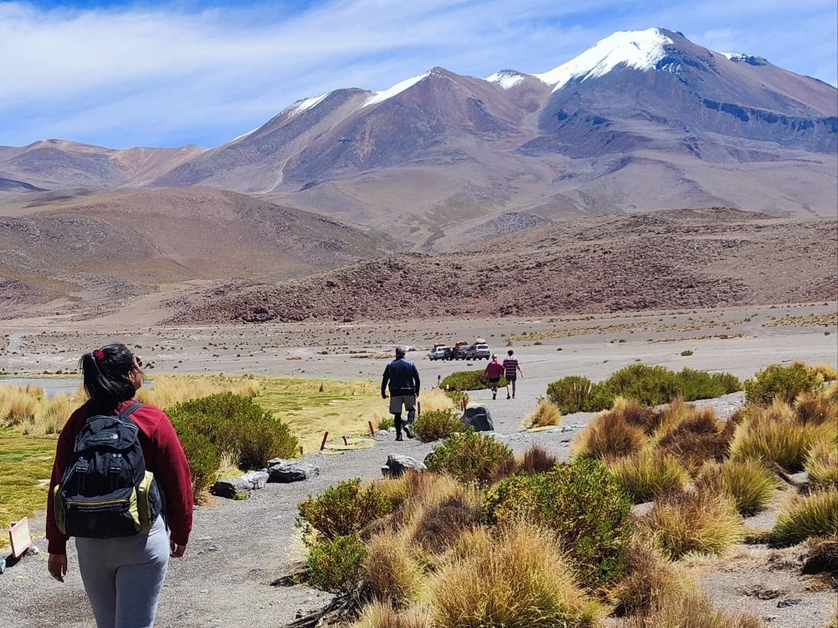 Walking the altiplano below a snow-capped volcano