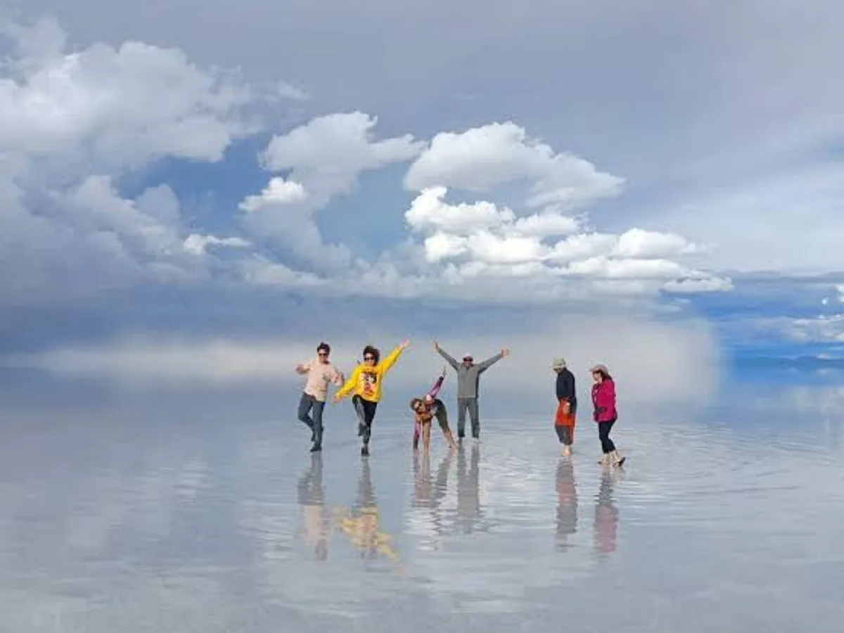 Travellers on the mirror, clouds reflected under their feet